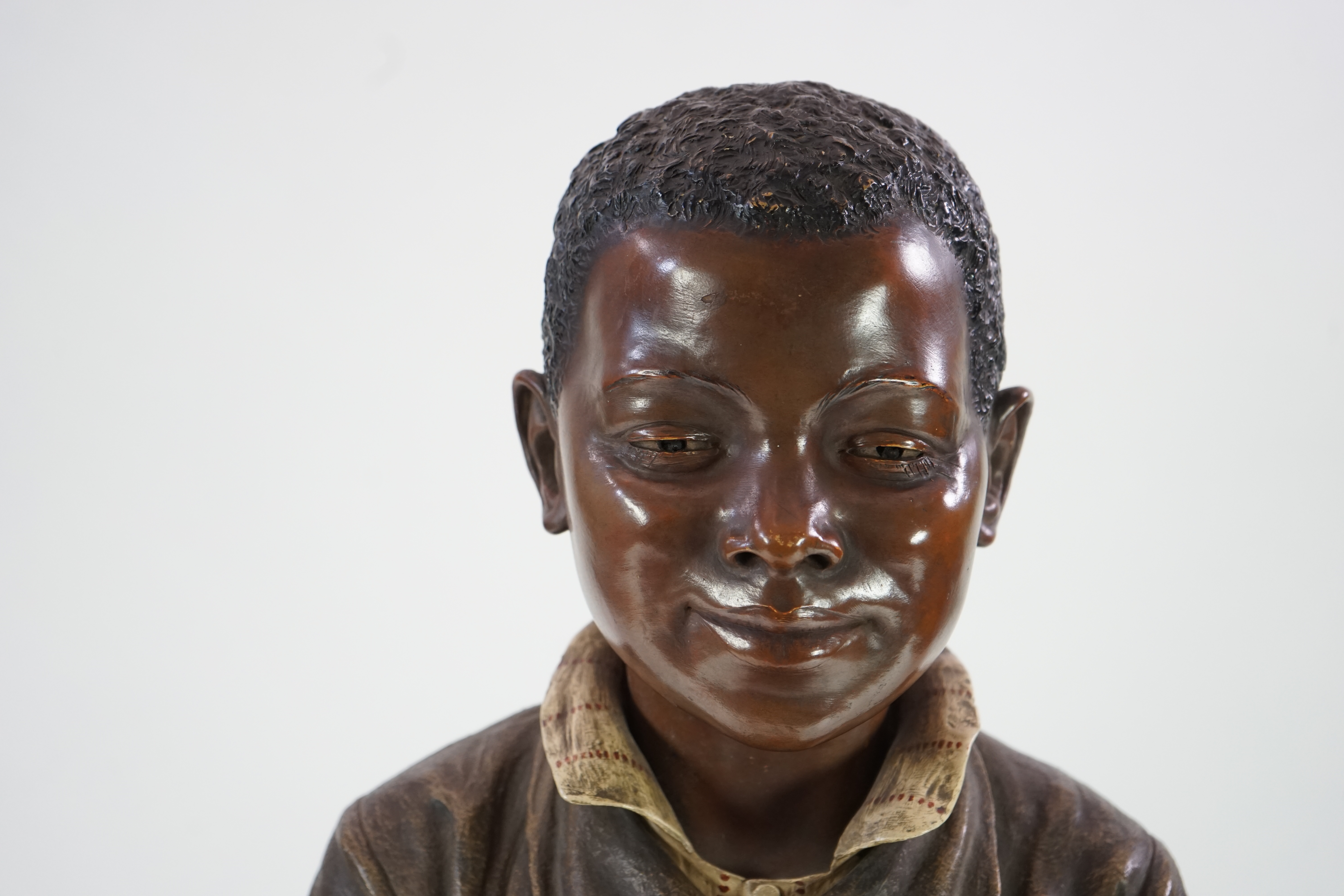 A late 19th century Friedrich Goldscheider life size cold painted terracotta figure of a black boy